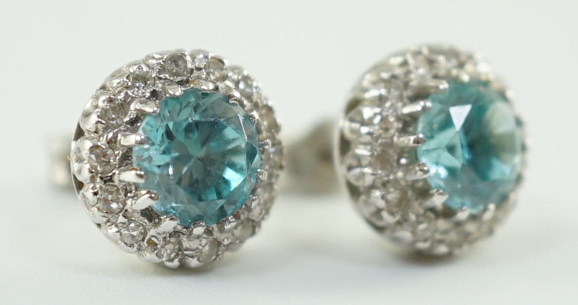 A pair of 18k white gold, blue zircon and diamond set circular cluster ear studs